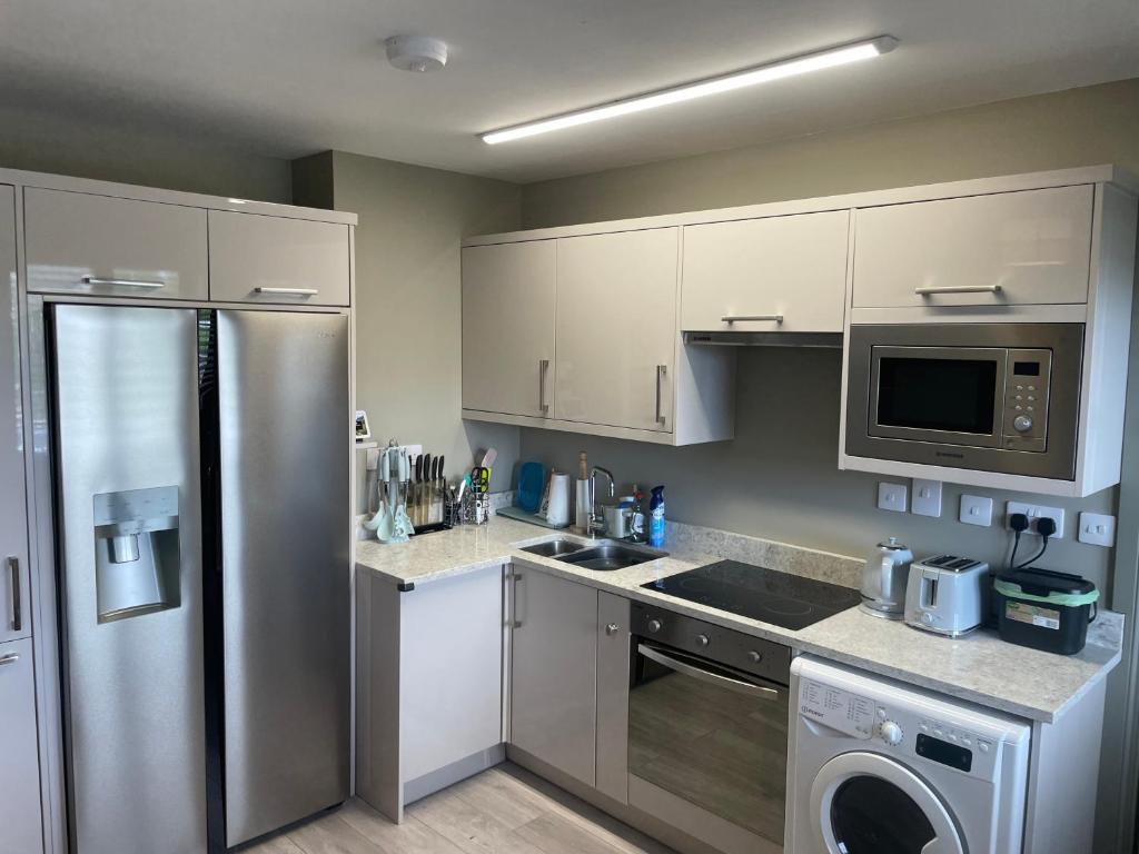 a kitchen with a stainless steel refrigerator and a dishwasher at Small,smart,tidy 2 bed apartment in Galway