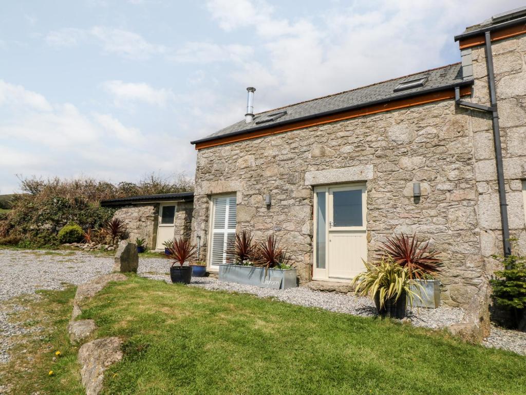 a stone cottage with a garden in front of it at Leghorn in St Austell