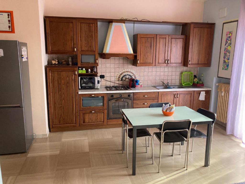 une cuisine avec des placards en bois et une table avec des chaises dans l'établissement DOLOMITI 5.3, à Vérone
