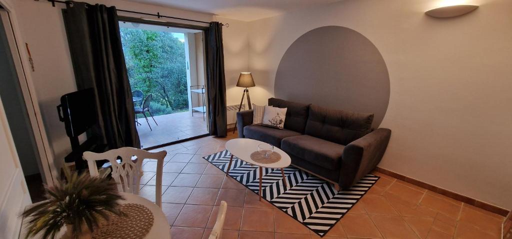 a living room with a couch and a table at Appartement sur golf de L'Isle-Sur-La-Sorgue in Saumane-de-Vaucluse