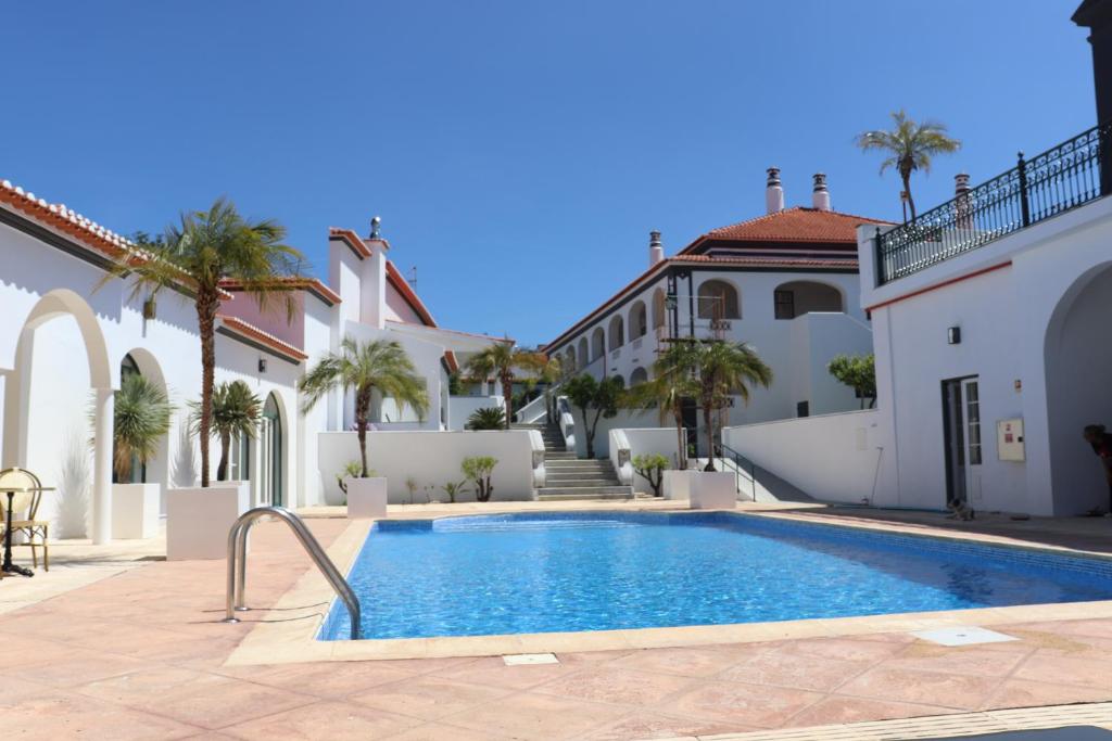 a swimming pool in front of a house at SOLAR DOS FRADES in Ferreira do Alentejo