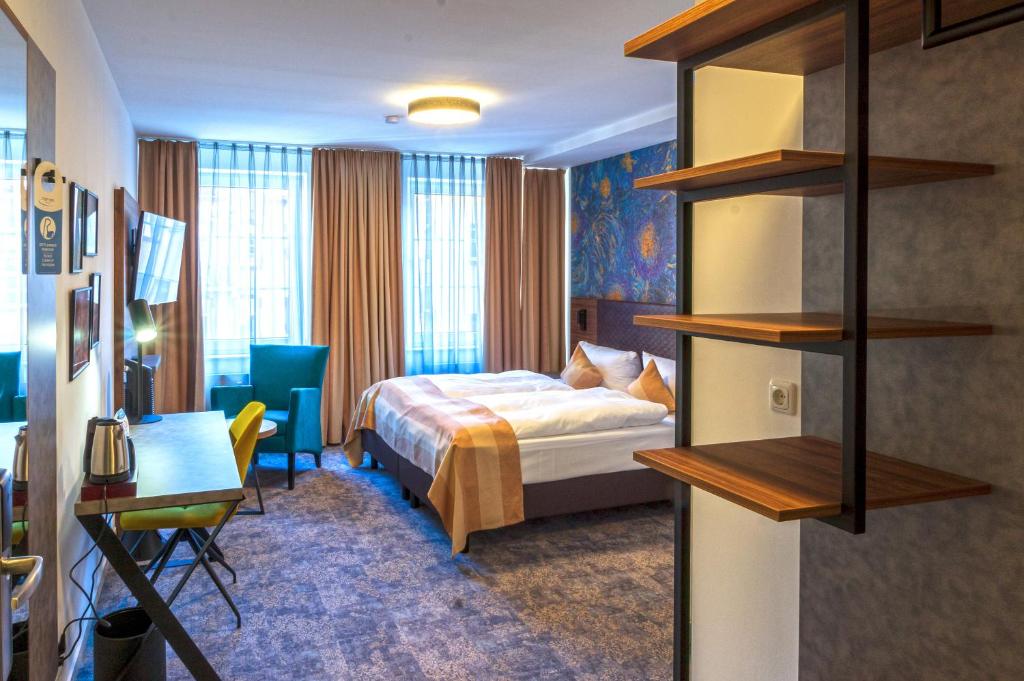 ギーセンにあるTrip Inn City Hotel Giessenのベッドとデスクが備わるホテルルームです。