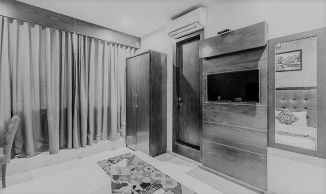 een woonkamer met een open haard en een televisie bij FabHotel Realm Inn in Mumbai