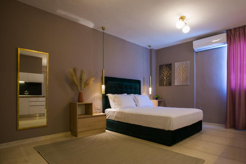 een slaapkamer met een groot bed en een spiegel bij Marizas luxury suites #1 in Thessaloniki