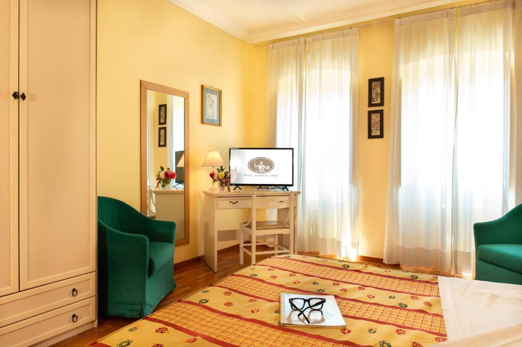 a room with a bed and a desk and a television at Hotel Minerva in Assisi