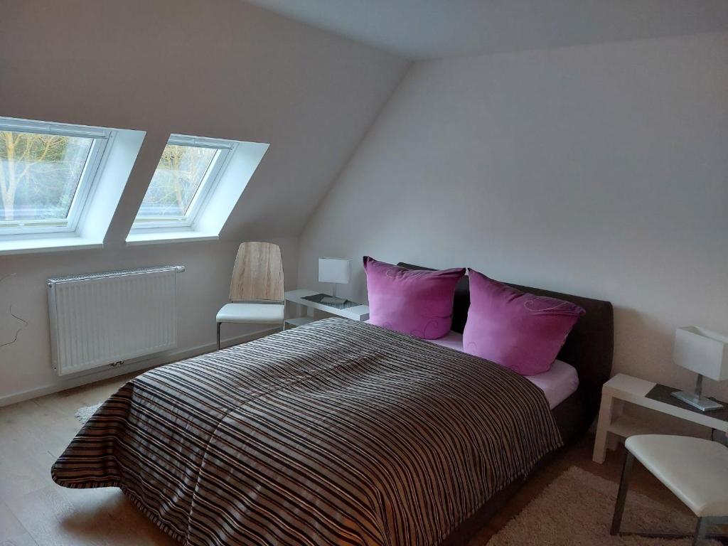 a bedroom with a large bed with purple pillows at Klosterblick in Bad Doberan
