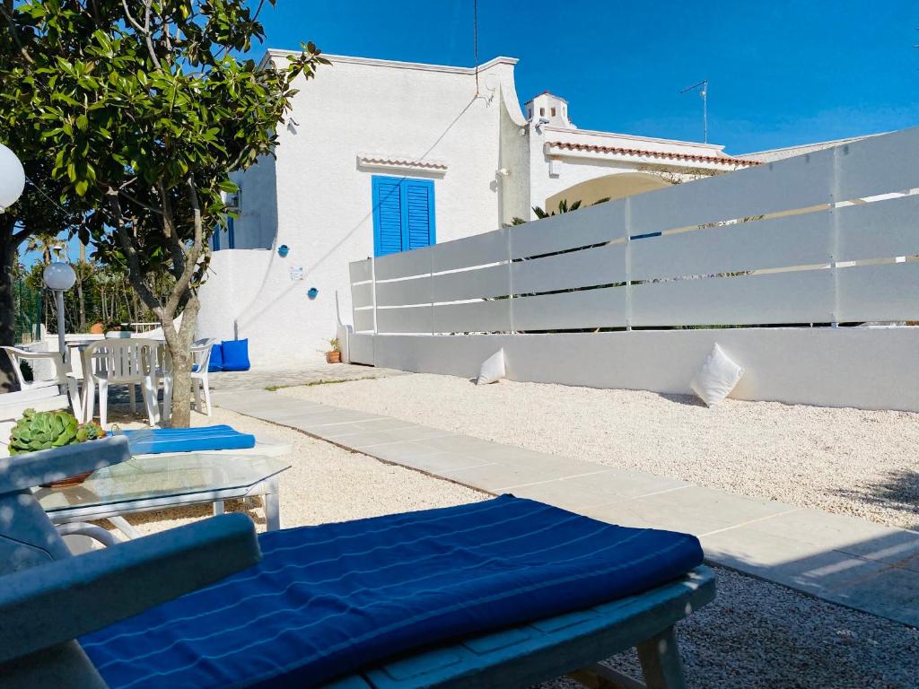 a bench with a blue cushion next to a fence at Dimora al Mare in Villanova di Ostuni