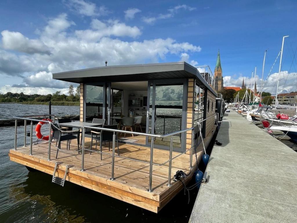 Hausboot Fjord Schleiliebe mit Biosauna und Dachterrasse in Schleswig في شلسفيغ: قارب المنزل على الماء في المرسى