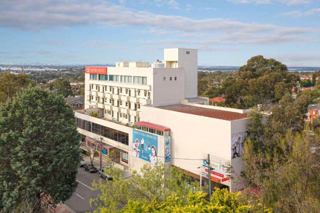 an overhead view of a white building with trees at Metro Hotel Miranda in Miranda