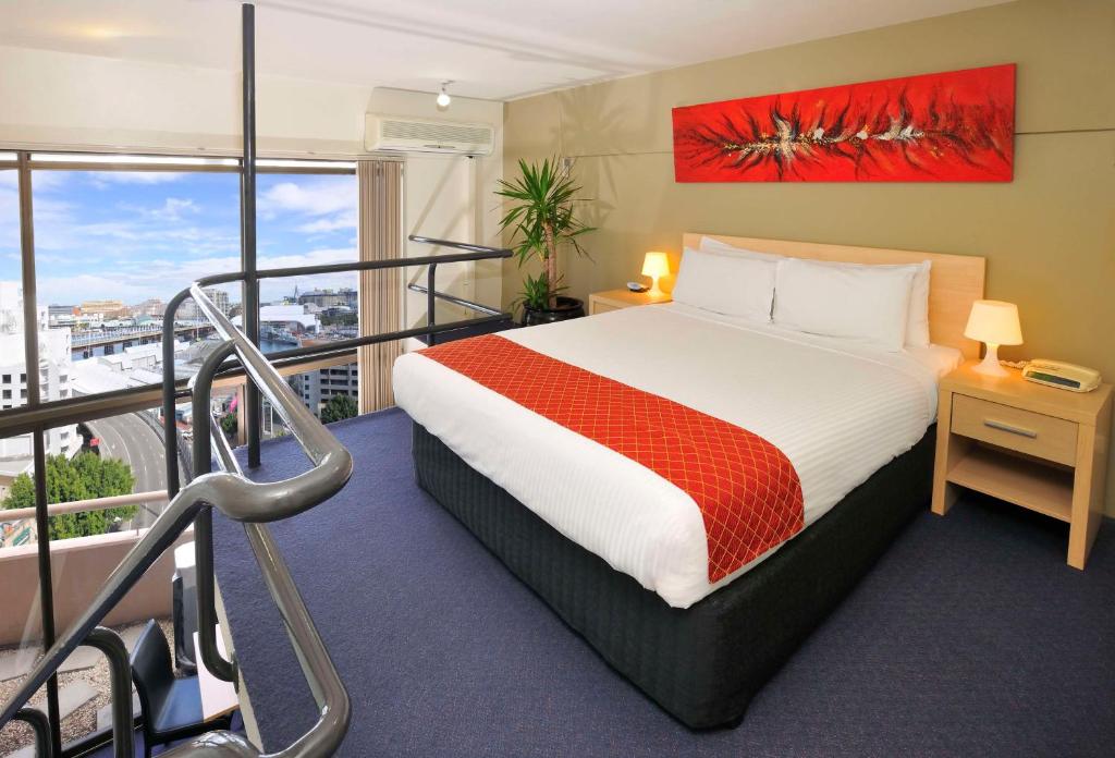 a hotel room with a bed and a balcony at Metro Apartments On Darling Harbour in Sydney