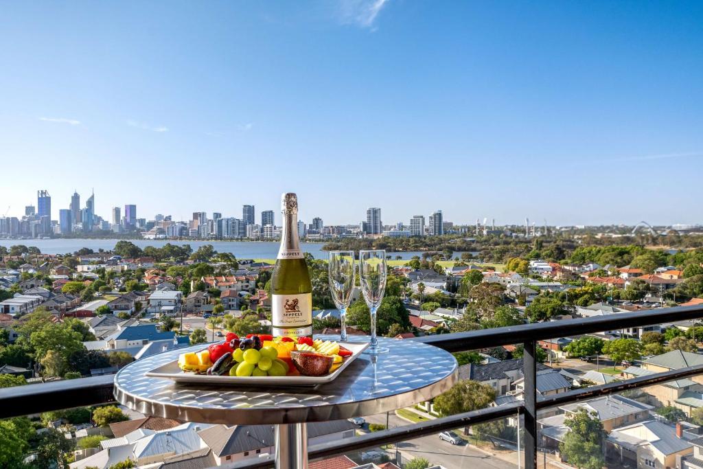 una bottiglia di champagne e un cesto di frutta su un tavolo di Metro Hotel Perth a Perth