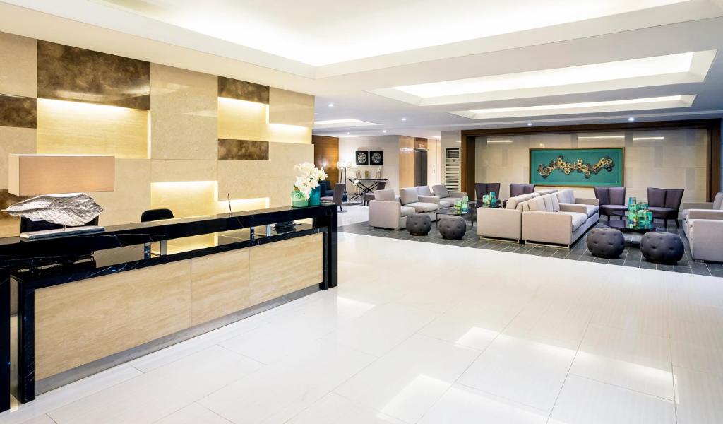 a lobby of a hotel with couches and chairs at Coast Residences Roxas Boulevard Manila in Manila