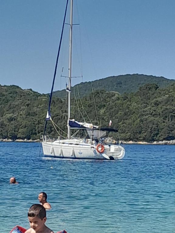 un velero en el agua con dos personas en el agua en Swing, en Corfú