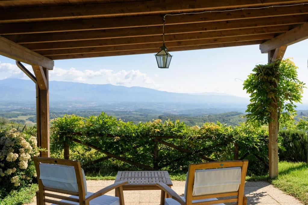 two chairs under a pergola with a view at La Tuia Vacanze apt for 4PP and apt for 2PP in Montevarchi