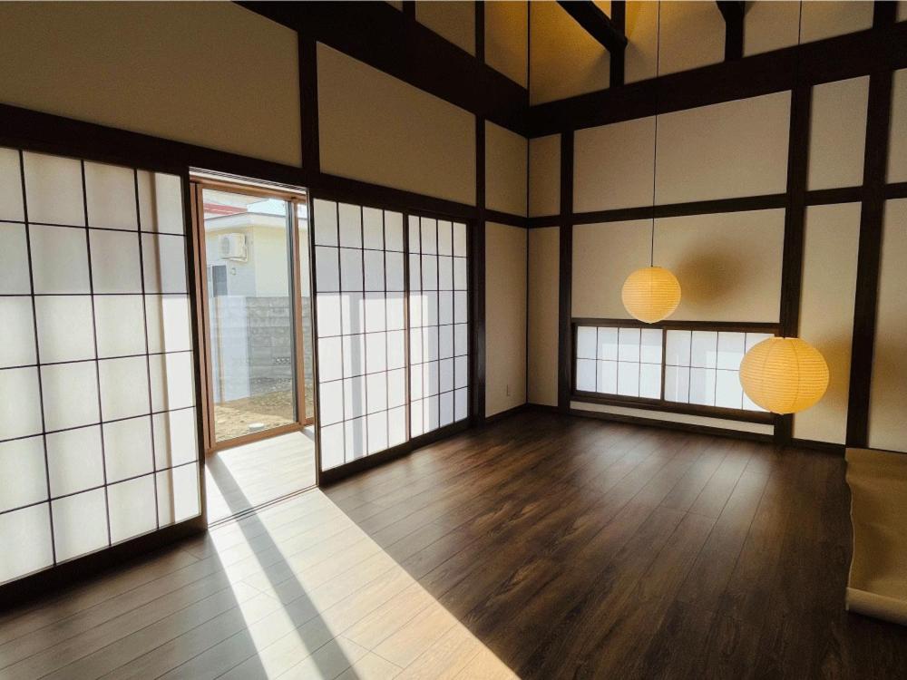 Habitación con 2 lámparas y suelo de madera. en ミロクハウス, en Daisen