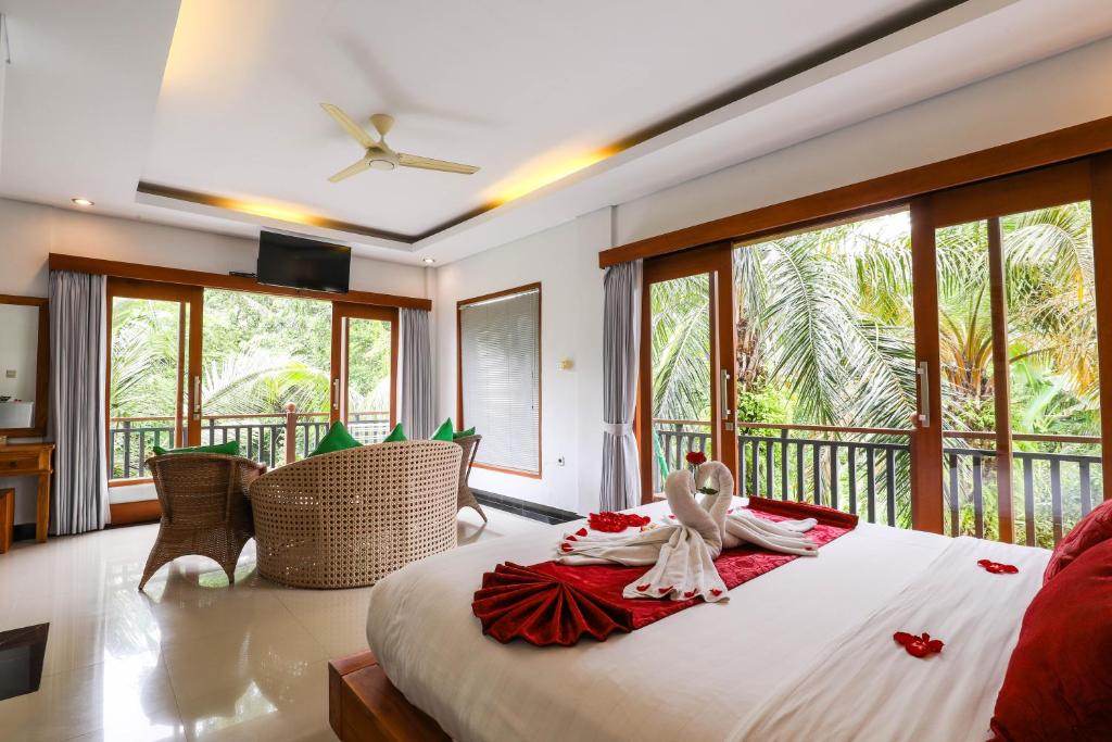 a bedroom with a large bed with a robe on it at Amoya Inn in Ubud