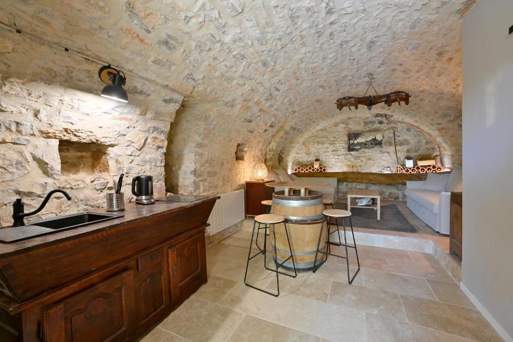 eine Küche mit einer Theke und einem Waschbecken in einem Zimmer in der Unterkunft Maison Chandolas - Charmante maison pour 10 voyageurs in Chandolas