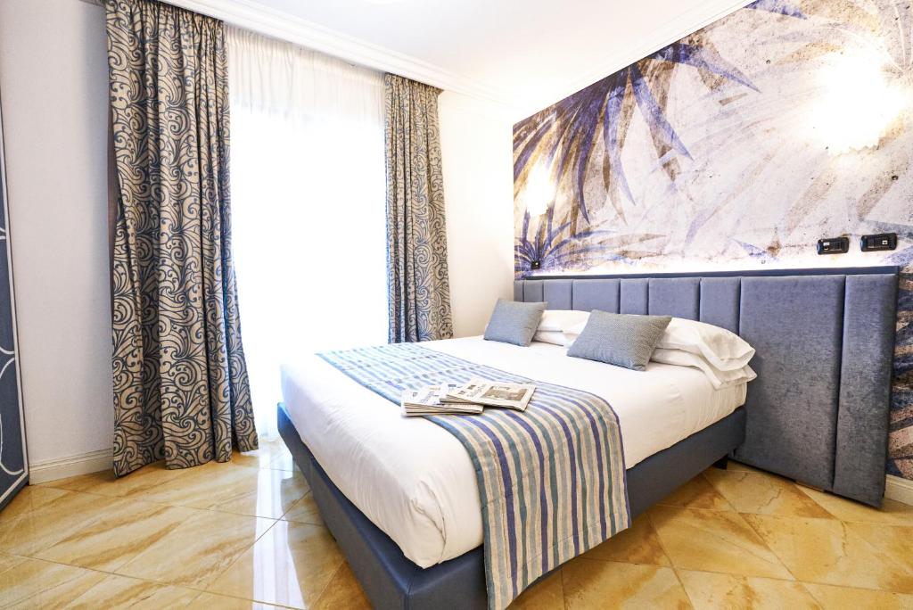 a bedroom with a bed with a painting on the wall at Hotel Oasi Di Kufra in Sabaudia