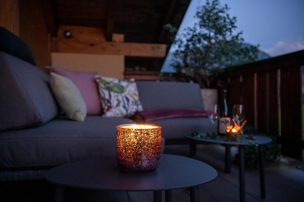 a living room with a couch and two tables with candles at SALZANO Apartments in Interlaken