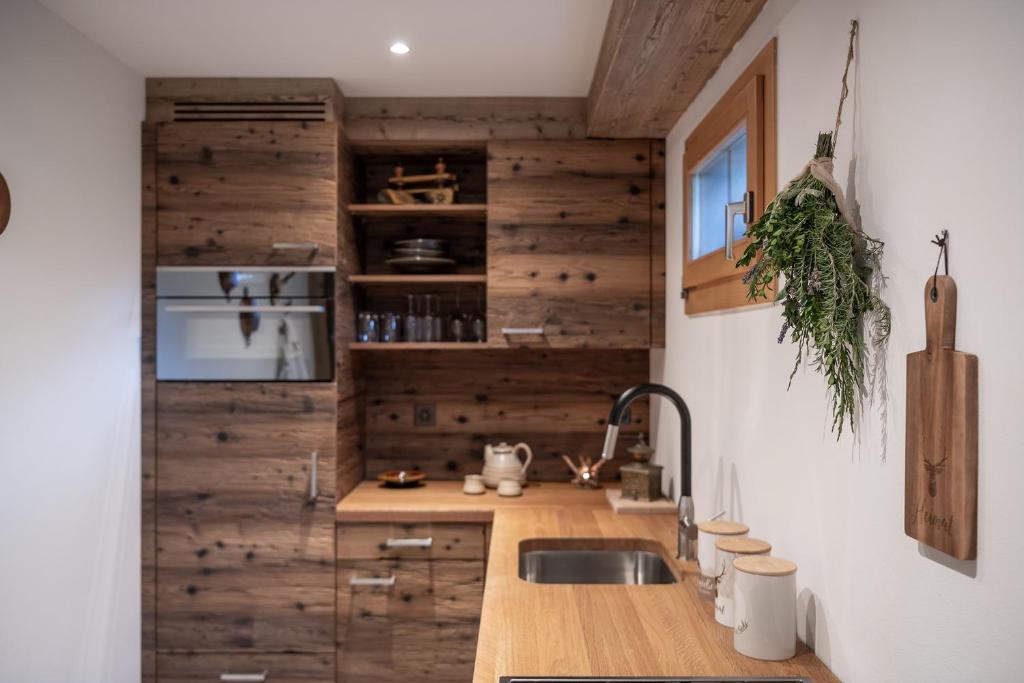 a kitchen with wooden walls and a sink at SALZANO Apartments in Interlaken