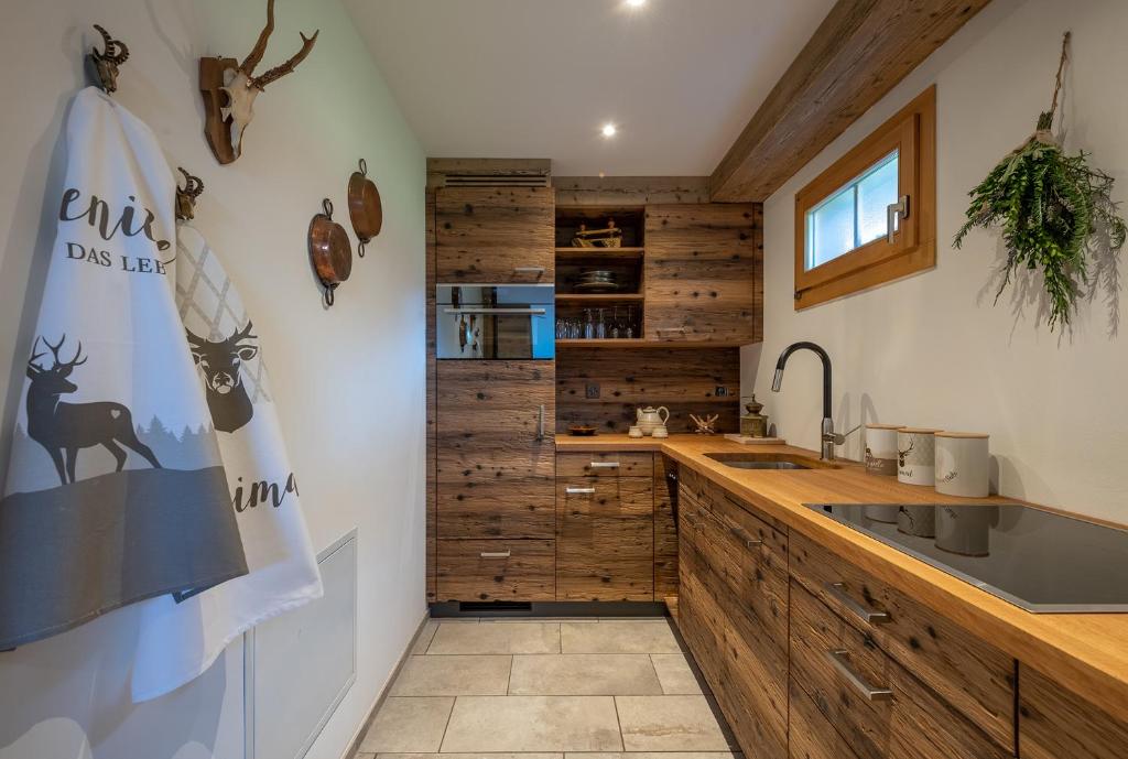 a kitchen with wooden walls and a counter with a sink at SALZANO Apartments in Interlaken
