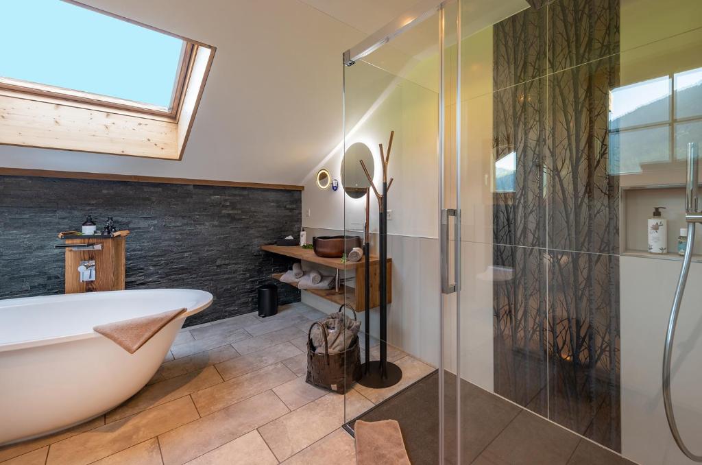 a bathroom with a tub and a glass shower at SALZANO Apartments in Interlaken