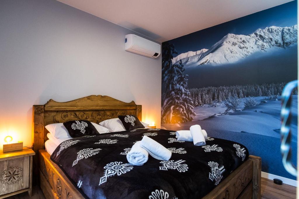 a bedroom with a bed with towels on it at Apartament Luna Góralka in Zakopane