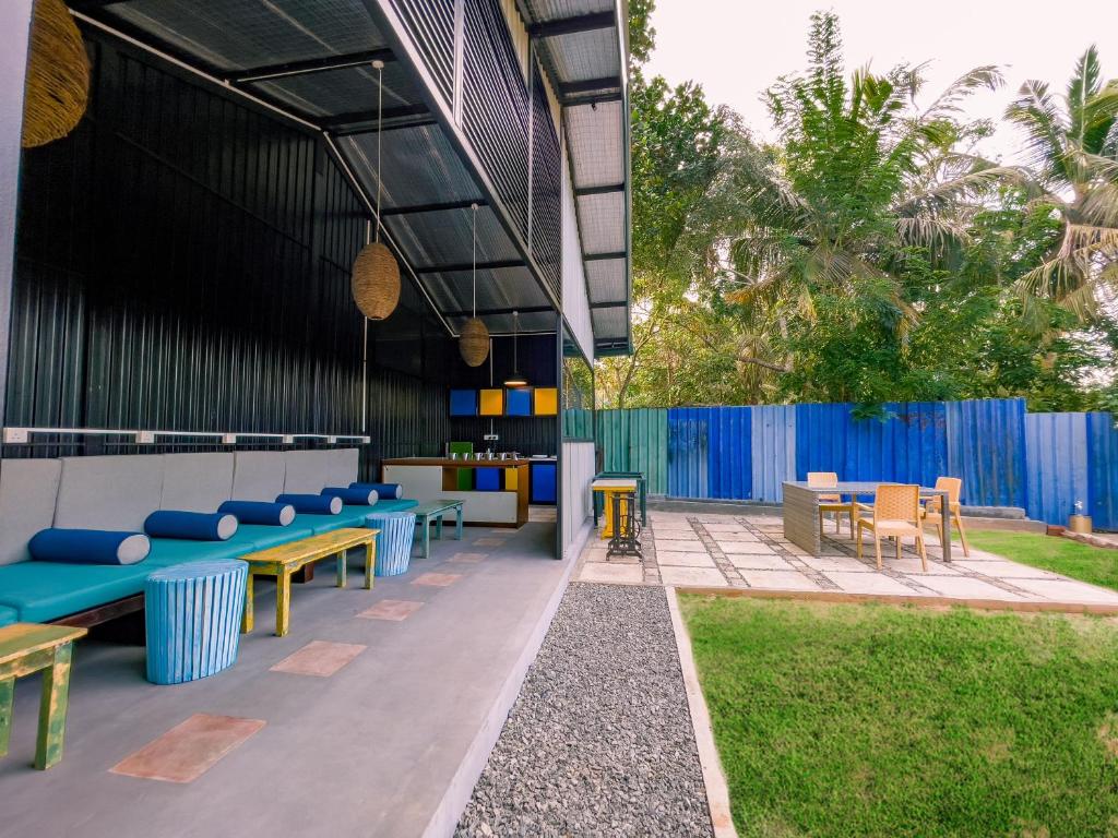 a patio with benches and tables and a fence at Lost & Found Hostel Weligama in Weligama