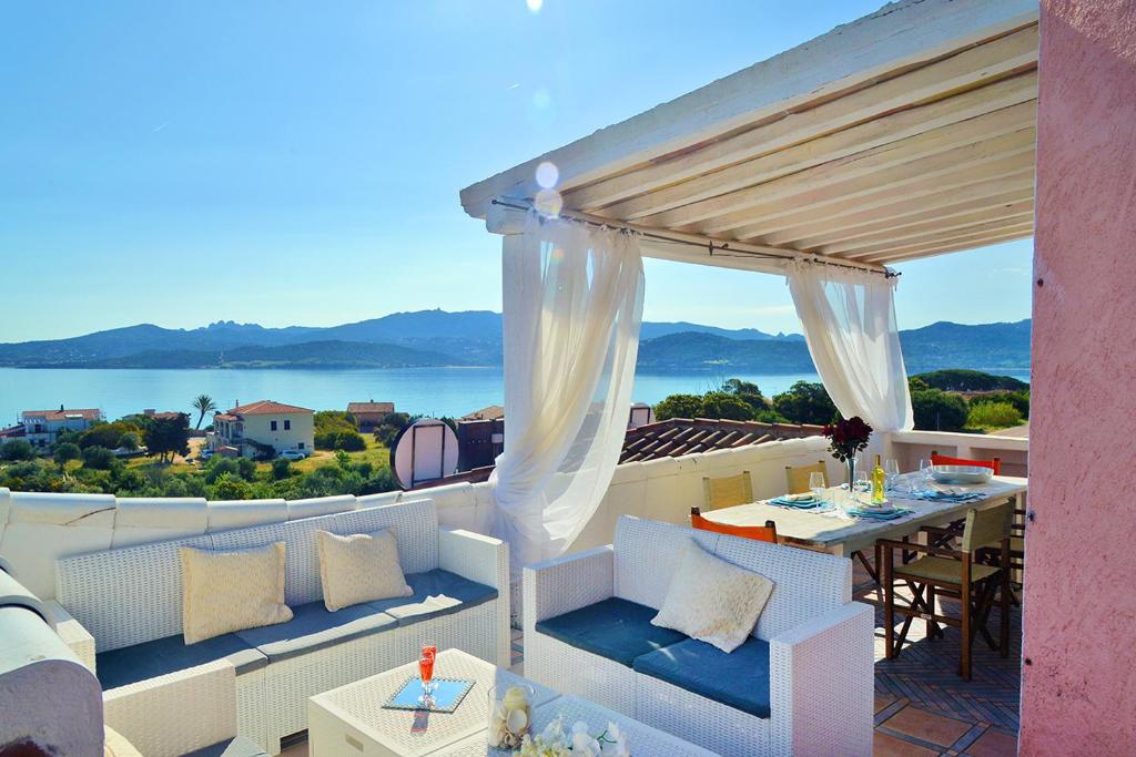 balcone con tavolo e vista sull'acqua di Case Vacanze La Conia a Cannigione