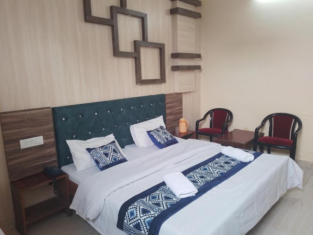 a bedroom with a large bed with blue and white pillows at Hotel Ishan in Katra