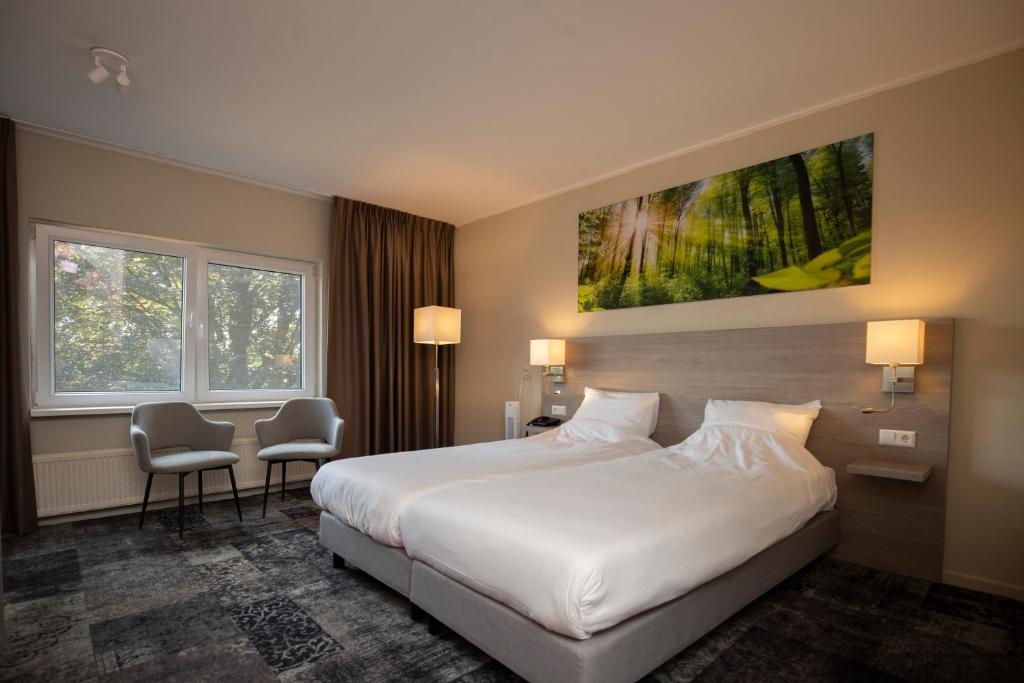 Postel nebo postele na pokoji v ubytování Fletcher Hotel-Restaurant Paasberg