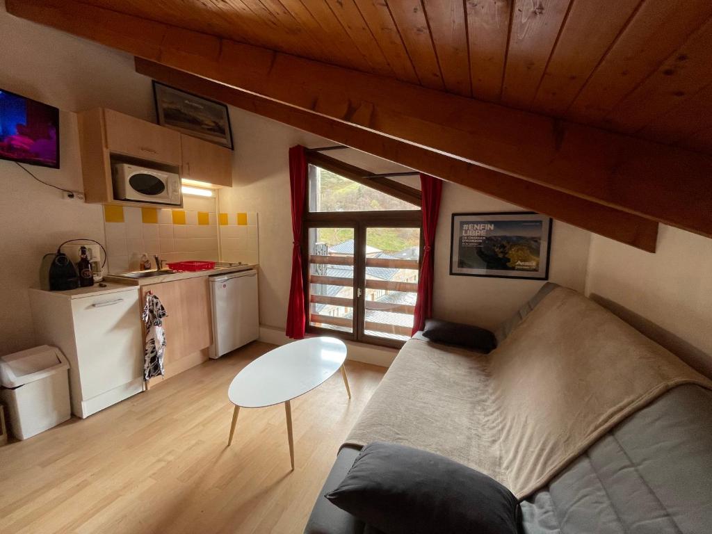Cette petite chambre dispose d'un canapé, d'une table et d'une cuisine. dans l'établissement Studio 1411, à Ustou