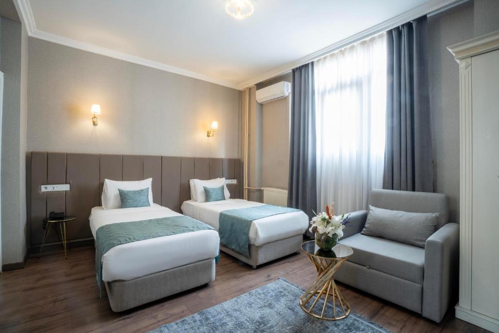 a hotel room with two beds and a couch at Valide Hotel in Istanbul