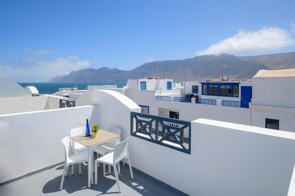 a balcony with a table and chairs on a building at Pleamar in Famara