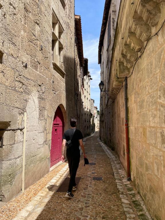 a man walking down a street in an alley at Le relais appartement aux charmes authentiques WIFI in Périgueux