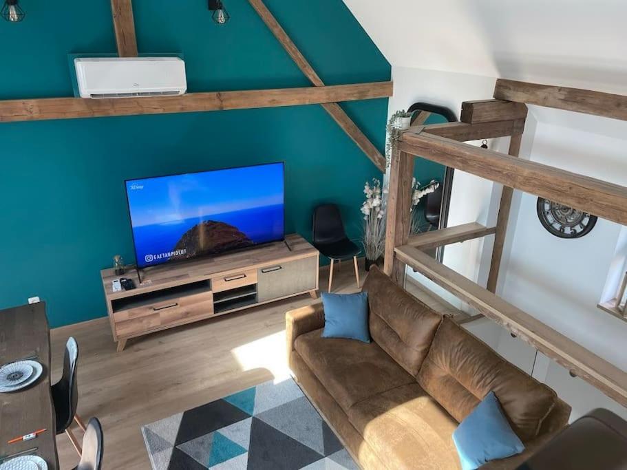 a living room with a couch and a flat screen tv at Gîte à 10 min d'Europa-park in Rhinau