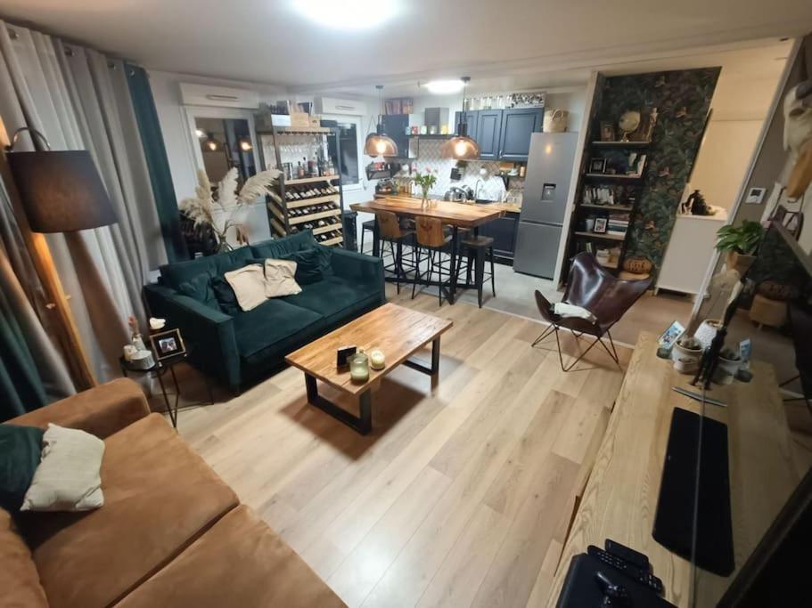 ein Wohnzimmer mit einem grünen Sofa und einem Tisch in der Unterkunft Avenue de Caen in Rouen
