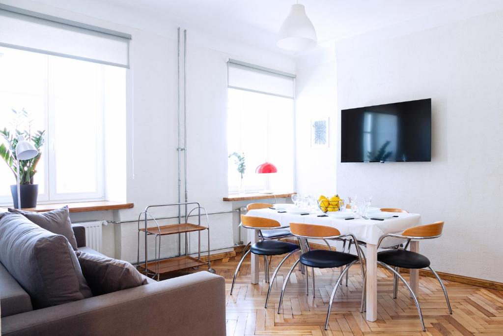 a living room with a white table and chairs at Kalamaja Park Apartment fast net 150 G, bath in Tallinn