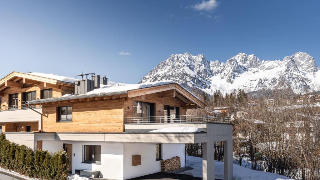 a house with snow covered mountains in the background at Mountain View Chalet Going in Going