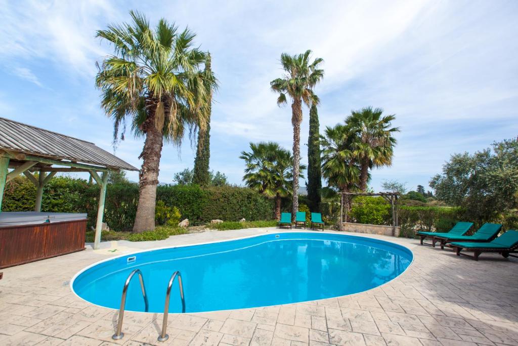una piscina con palme in un cortile di Villa Olive Grove 3 a Paphos
