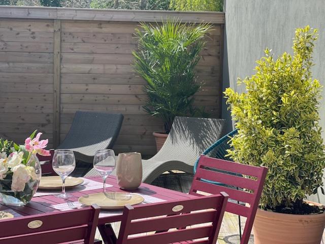 een tafel met 2 stoelen en wijnglazen op een patio bij Ma Rosalie in Le Crotoy