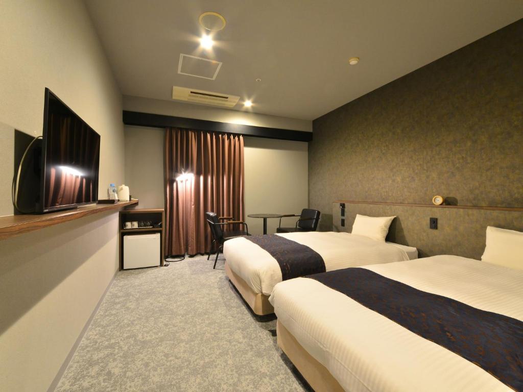 Postel nebo postele na pokoji v ubytování LC Goryokaku Hotel