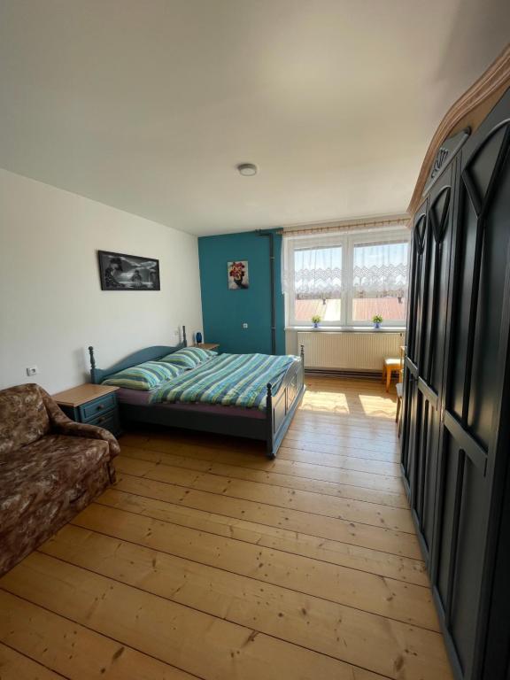 1 dormitorio con cama y sofá en Ubytování u Medvěda, en Rokytnice v Orlických horách
