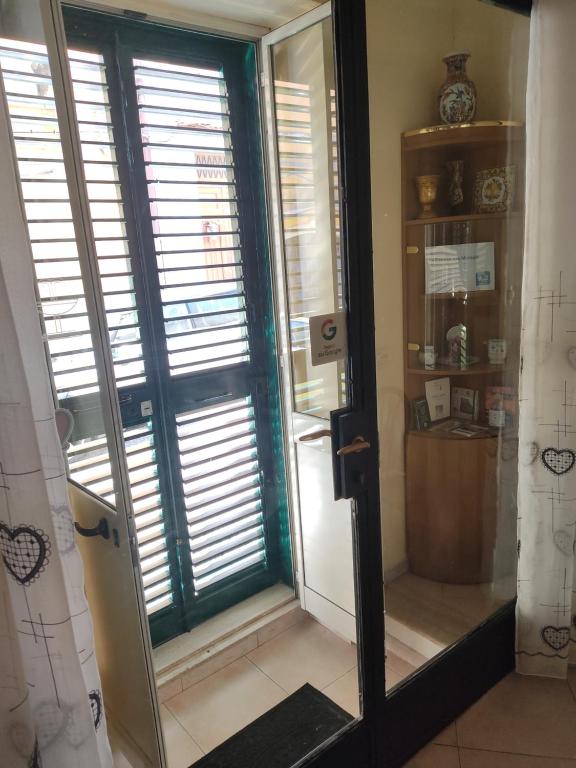 un baño con una ventana con persianas. en La Casa Di Via Marzulli, en Acireale