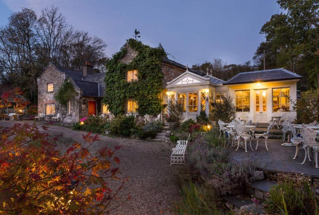 a house with a patio and tables and chairs at Luxury Country House Glendalough Wicklow in Laragh