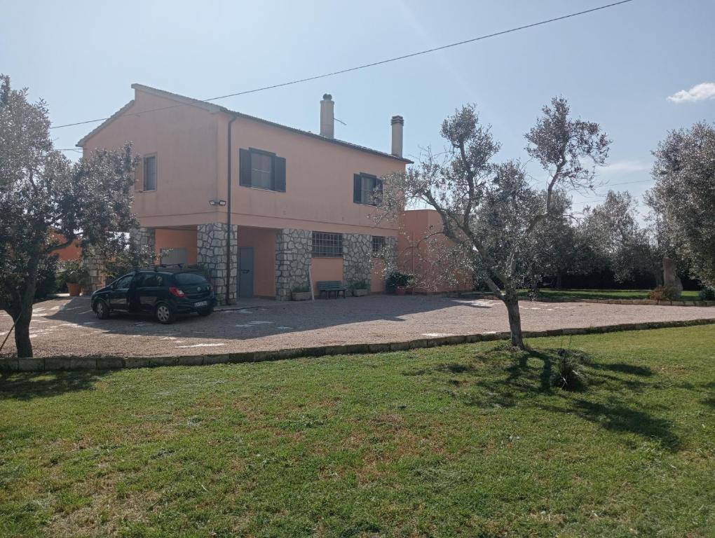 een huis met een auto ervoor geparkeerd bij Villa in campagna tra natura e verde in Montalto di Castro
