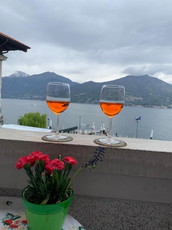 two glasses of wine sitting on a ledge with flowers at Zippity Doo Dah - Menaggio Home - Como Lake in Menaggio
