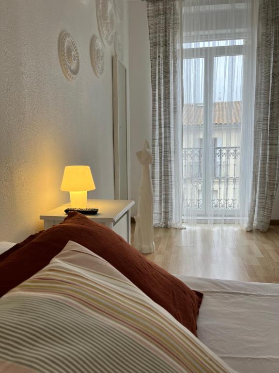 sypialnia z łóżkiem, lampką i oknem w obiekcie Les Enfants Terribles w mieście Villeneuve-lès-Béziers