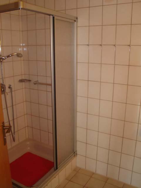 a shower with a glass door in a bathroom at Haus Düne, Ferienwohnung 21 in Cuxhaven