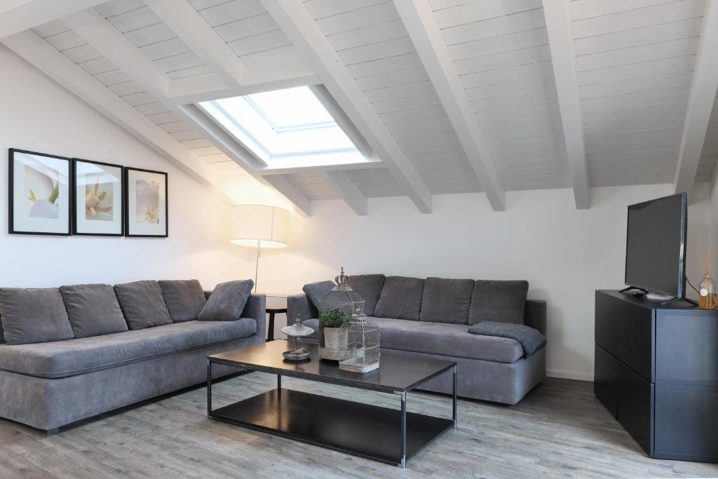 a living room with two couches and a tv at Nen&egrave; - La Scalinata apartments in Bellagio